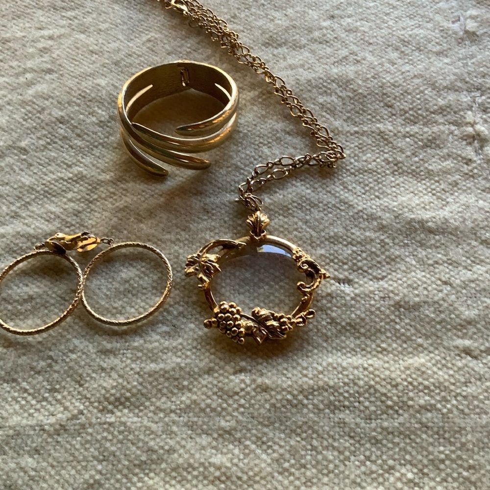 Goldtone snap close bracelet with a golden necklace and golden hoop earrings